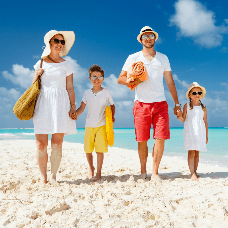 Family of four walking on a beach.