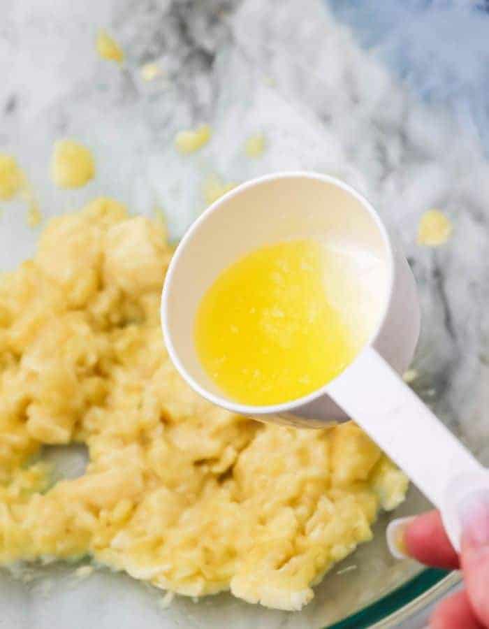 Melted butter being added to mashed banana.
