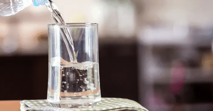 water pouring into a glass for the 30 day water challenge for weight loss