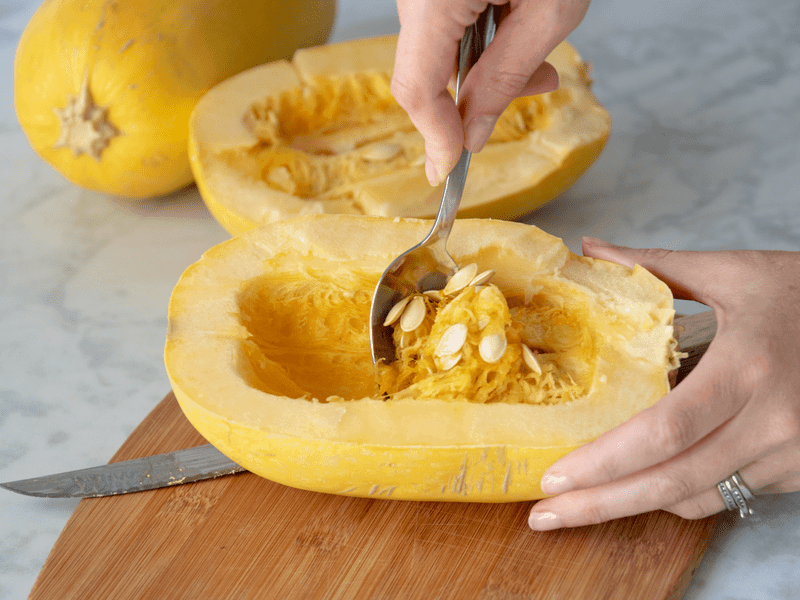 scarping seeds out of spaghetti squash with spoon