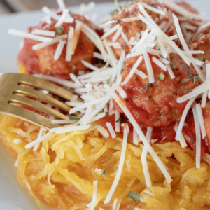 spaghetti squash with turkey meatballs on a white plate ready to eat