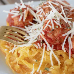 spaghetti squash with turkey meatballs on a white plate ready to eat