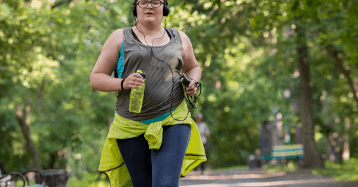 woman running in park to burn belly fat