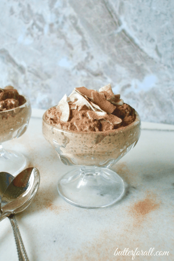 chocolate coconut almond chia seed pudding in a glass dessert cup with spoon beside it