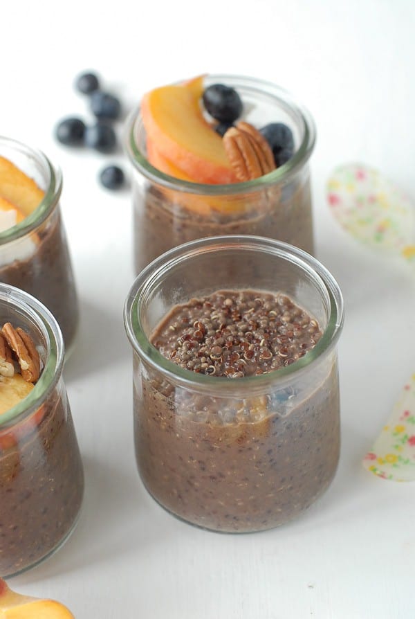quinoa chia seed chocolate pudding in glasses with garnishments of fruit and nuts
