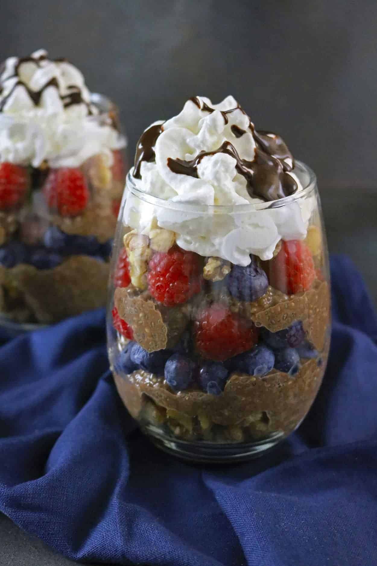 pumpkin pie spice chia pudding in a glass with fruit layered and whipped topping