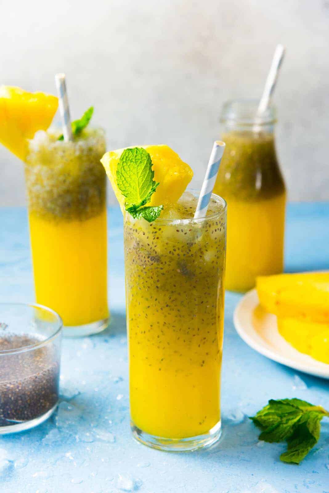 3 glasses with yellow colored vanilla pineapple chia fresca with garnish on top