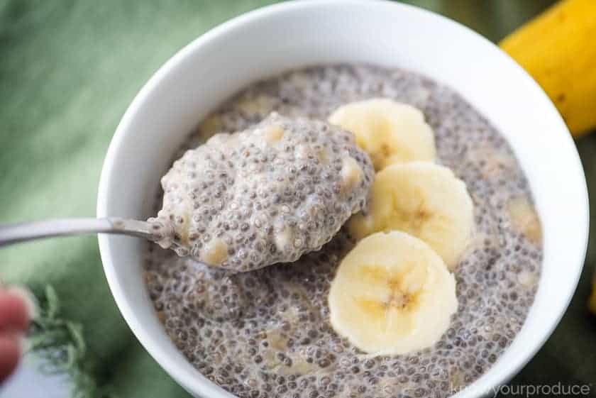 chia pudding with bananas in a white bowl with a spoon