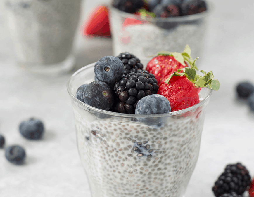 chia pudding with fruit on top in a clear glass container