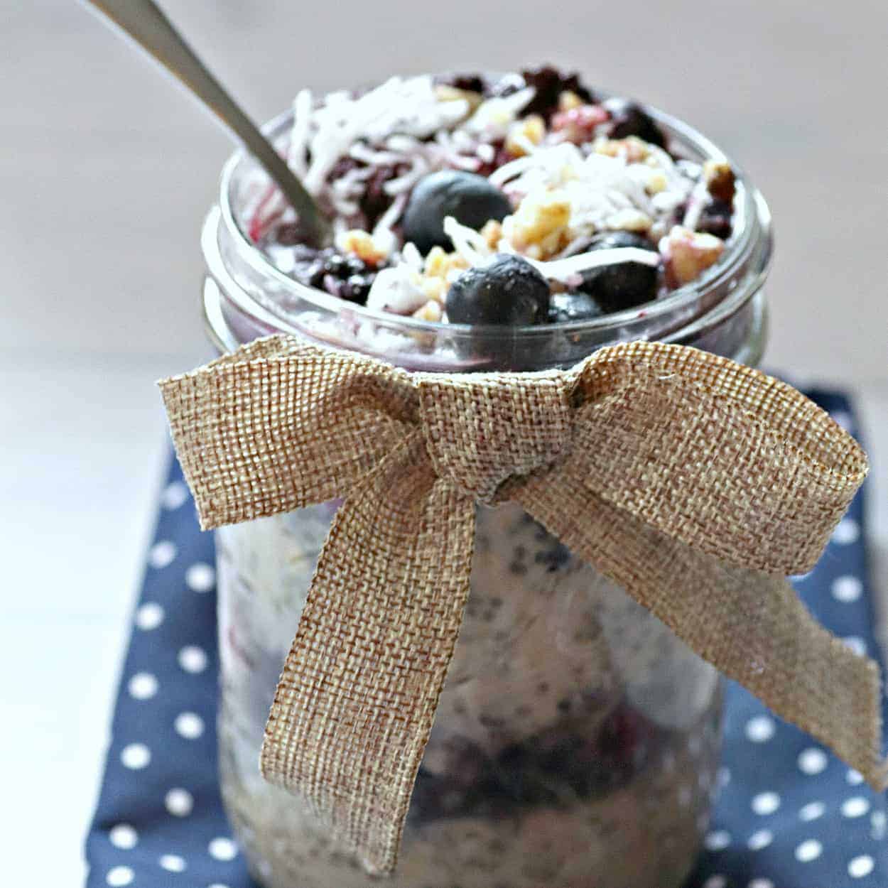 layered overnight oats in a jar with a bow