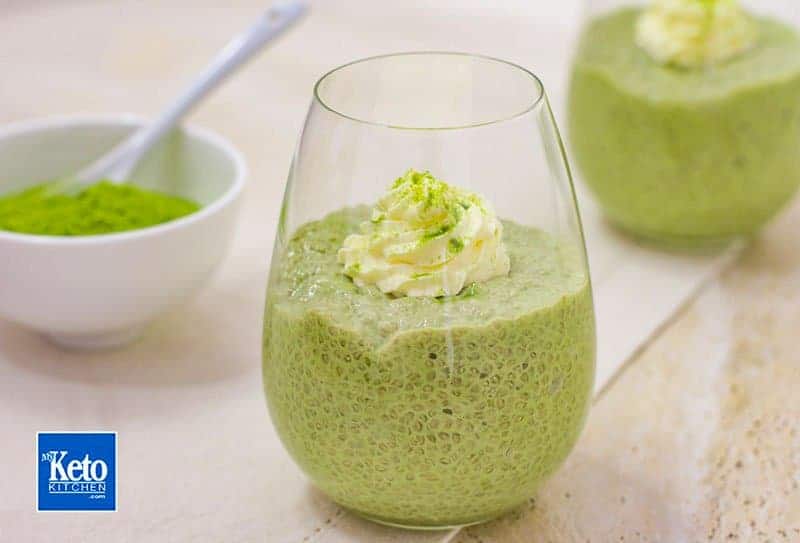 green matcha chia seed pudding in a glass with a dollop of whipped cream on top