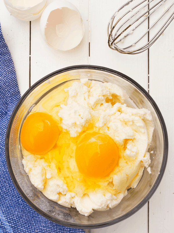 ricotta cheese with 2 eggs ready to be mixed in a bowl