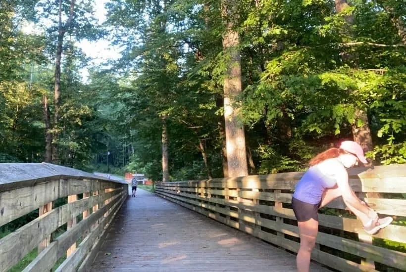 stephanie tying shoe on bridge during daily walk