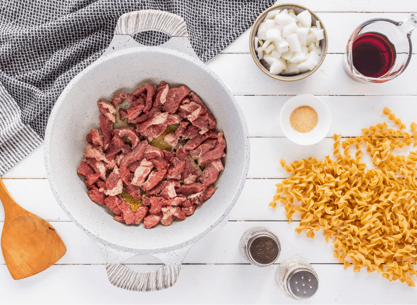 sliced steak in dutch oven with oil 