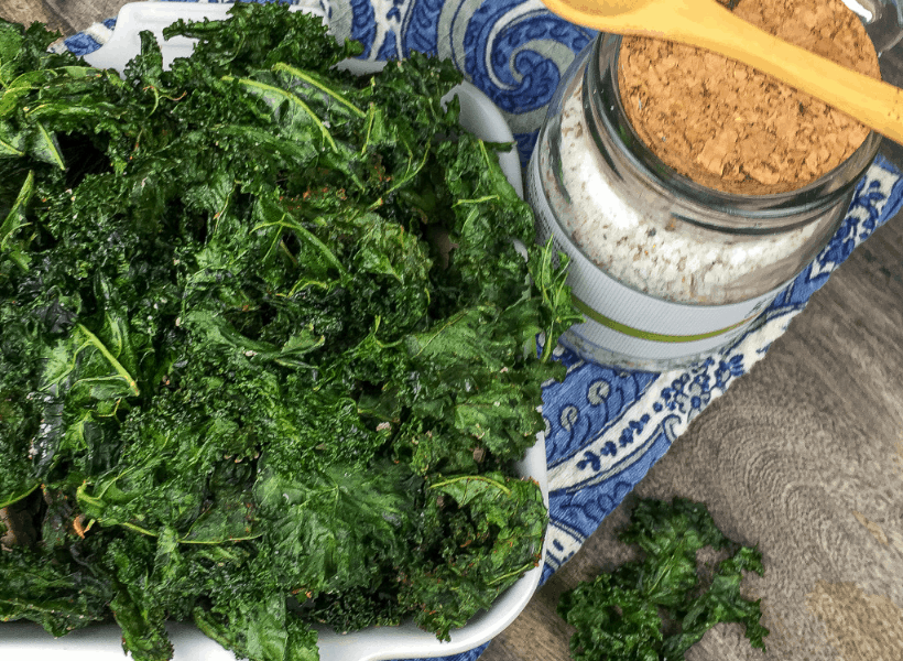 bowl of crispy kale chips with seasoning after baked in oven