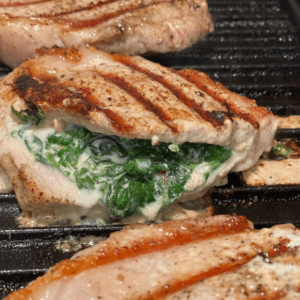 stuffed pork chops with spinach and cheese cooking on the indoor grill