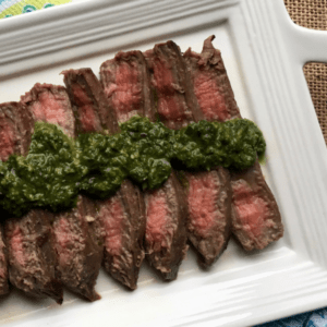 flank steak with chimichurri on a plate