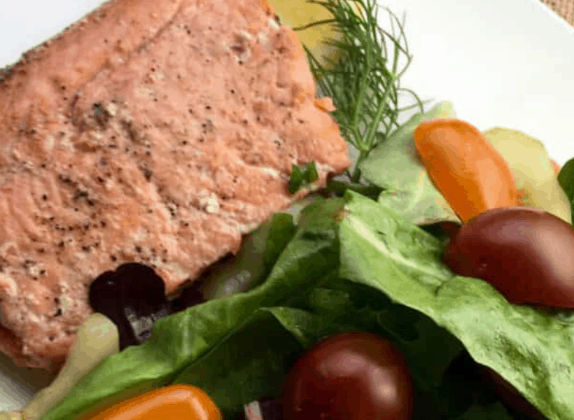 salmon with dill and salad on a white plate