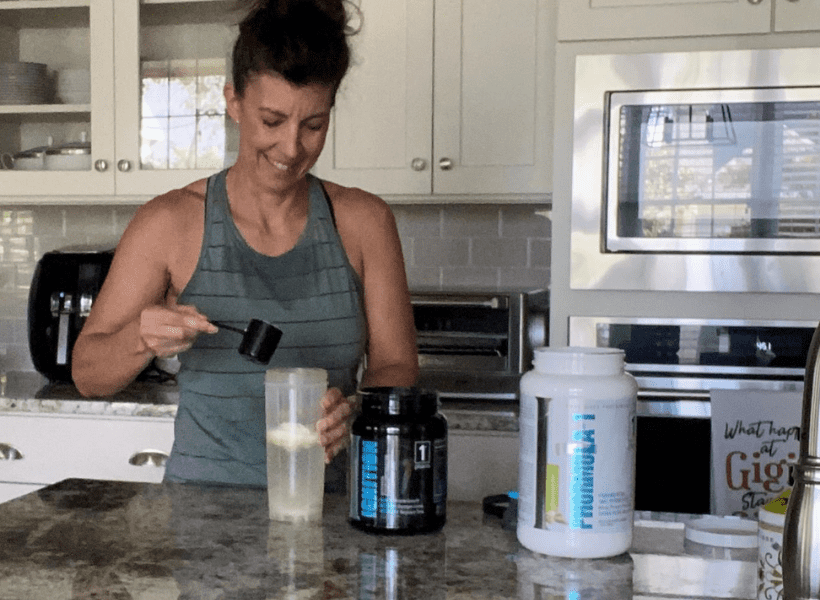 woman mixing post workout protein shake in kitchen