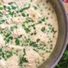 creamy quinoa with chicken and peas in a skillet