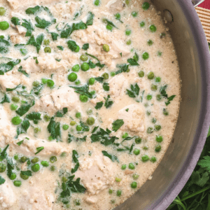 creamy quinoa with chicken and peas in a skillet