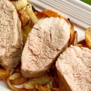plate of sliced roasted tenderloin on bed of apples and fennel roasted