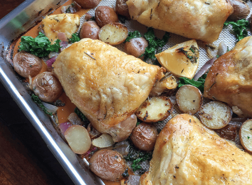 chicken thighs red potatoes and kale on sheet pan after baking in oven