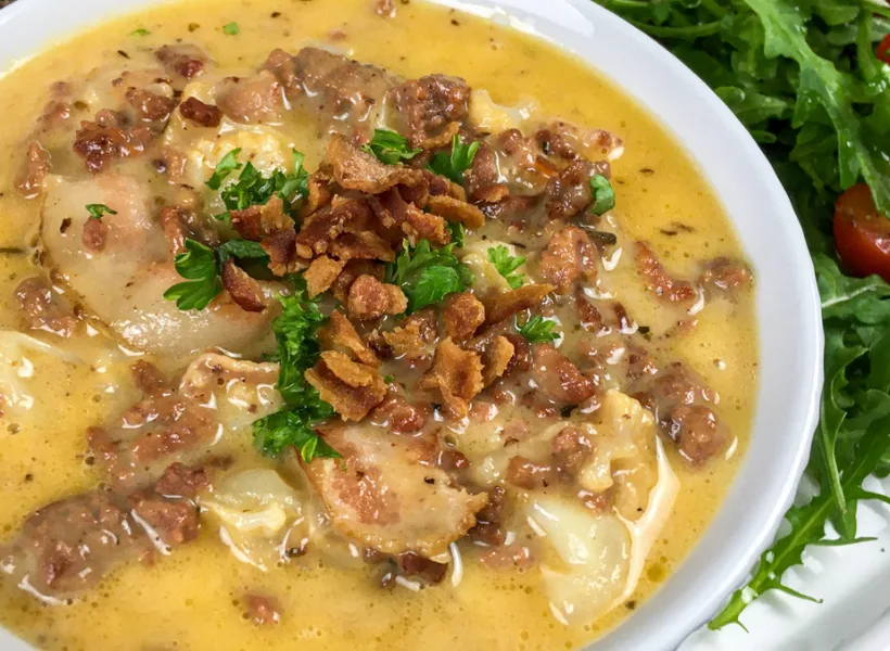 keto bacon cheeseburger soup in a white bowl with fresh chopped parsley as garnish on top