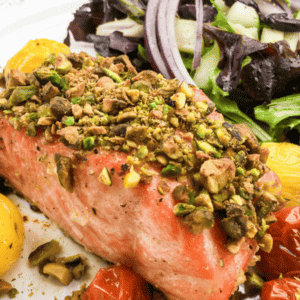 salmon crusted with pistachio mix with salad on plate