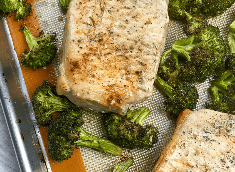 2 pork chops baked on sheet pan with broccoli