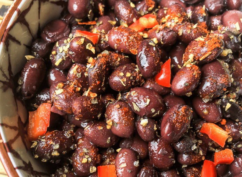 upclose image of black beans with crushed red peppers and red bell peppers