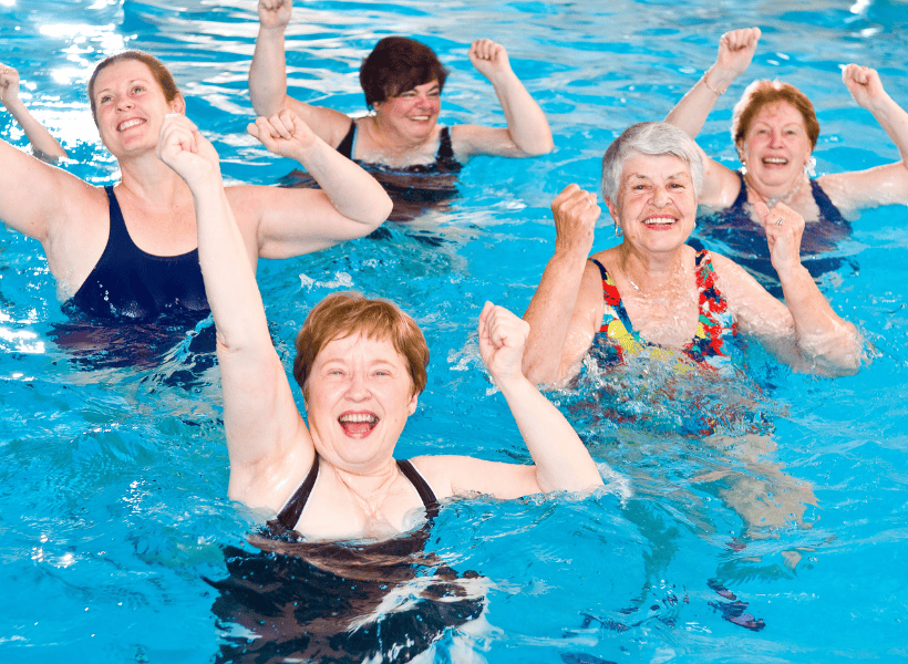 class of water aerobics of 5 ladies looking at the camera excited 