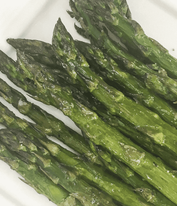 plated oven roasted asparagus on a white plate