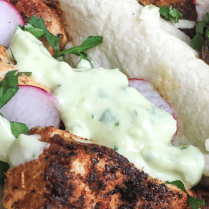 three fish tacos with blackening and creamy avocado sauce in soft taco shells