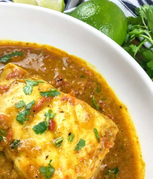 piece of fish in curry in a white bowl