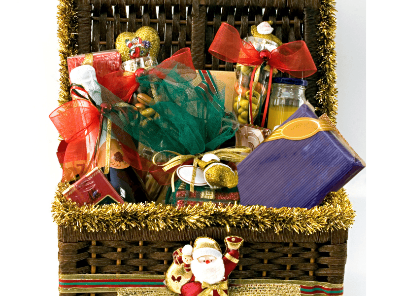 large basket filled with various healthy food gifts with a santa on the front