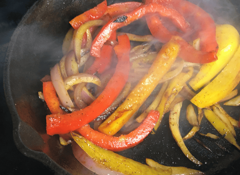 sauteed peppers and onions in a cast iron skillet