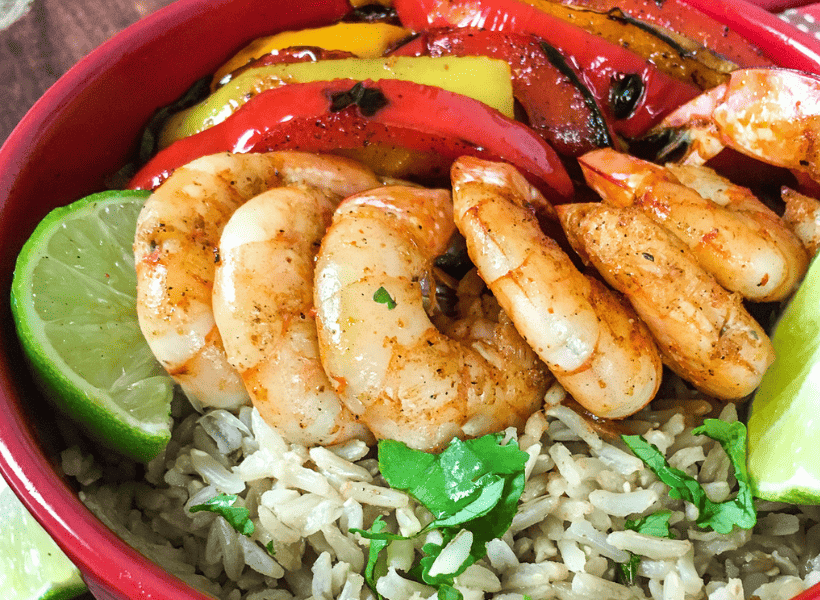 red bowl with cilantro rice, shrimp and fajitas peppers and onions