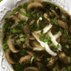 white bowl of chicken marsala soup with parsley garnishment