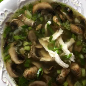white bowl of chicken marsala soup with parsley garnishment