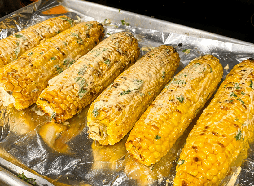 corn on cookie sheet with seasoning for oven