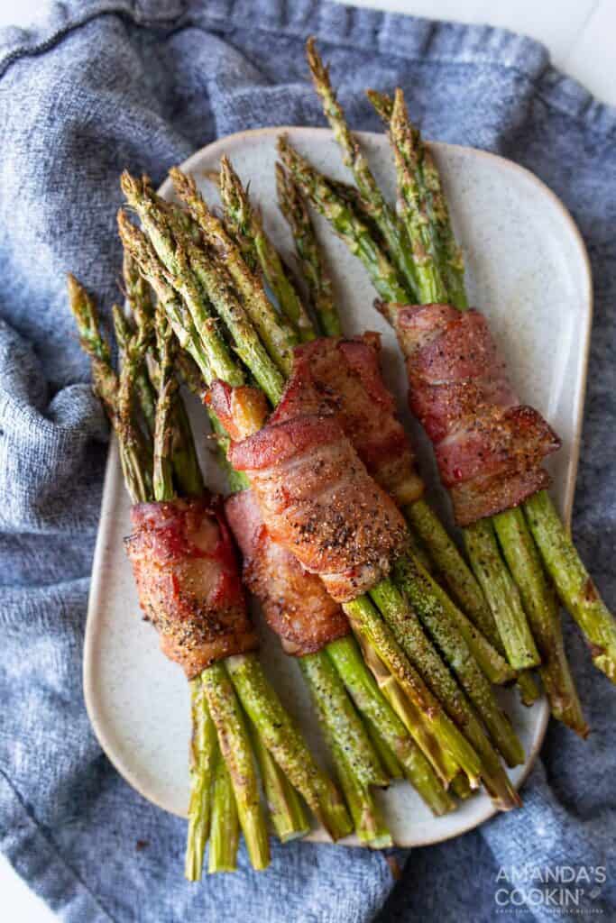 air fryer bacon wrapped asparagus on white plate