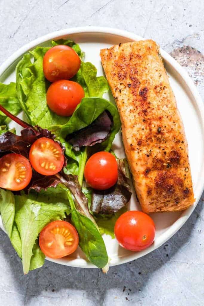 air fryer salmon on a plate with salad
