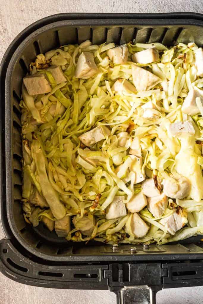 chicken and cabbage in an air fryer about to be cooked
