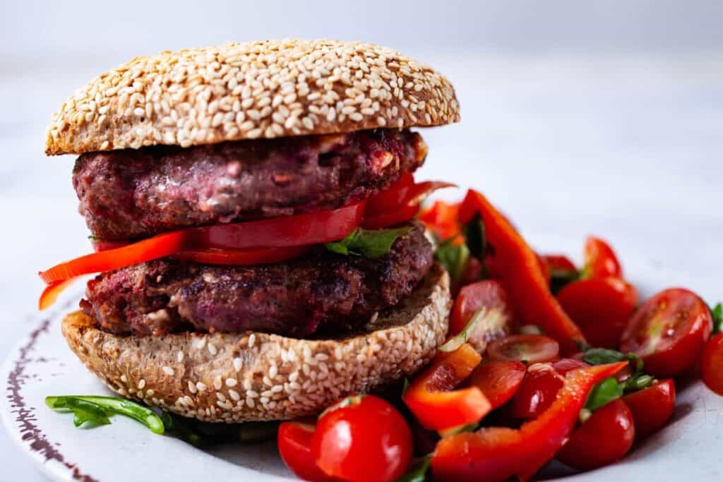gourmet burgers on gluten free bun with cherry tomatoes side dish