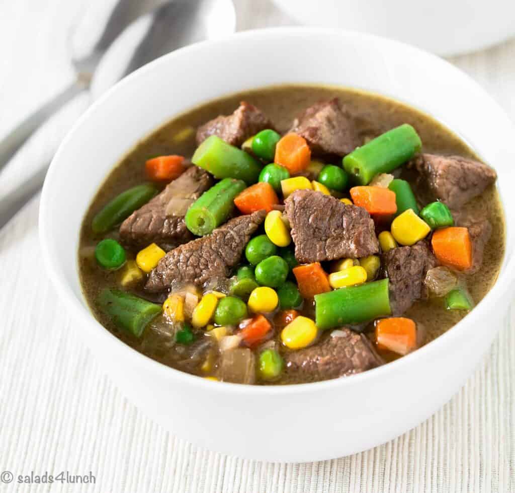 beef stew from crockpot with green beans, green peas, carrots, corn and beef