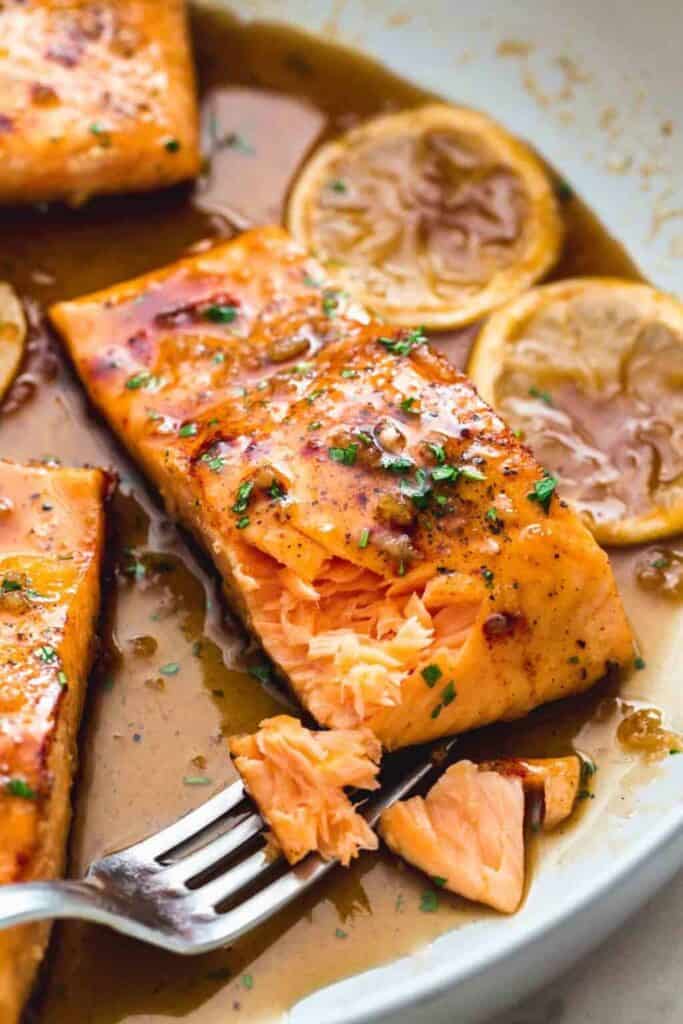 salmon with honey fried on stove top on plate with fork