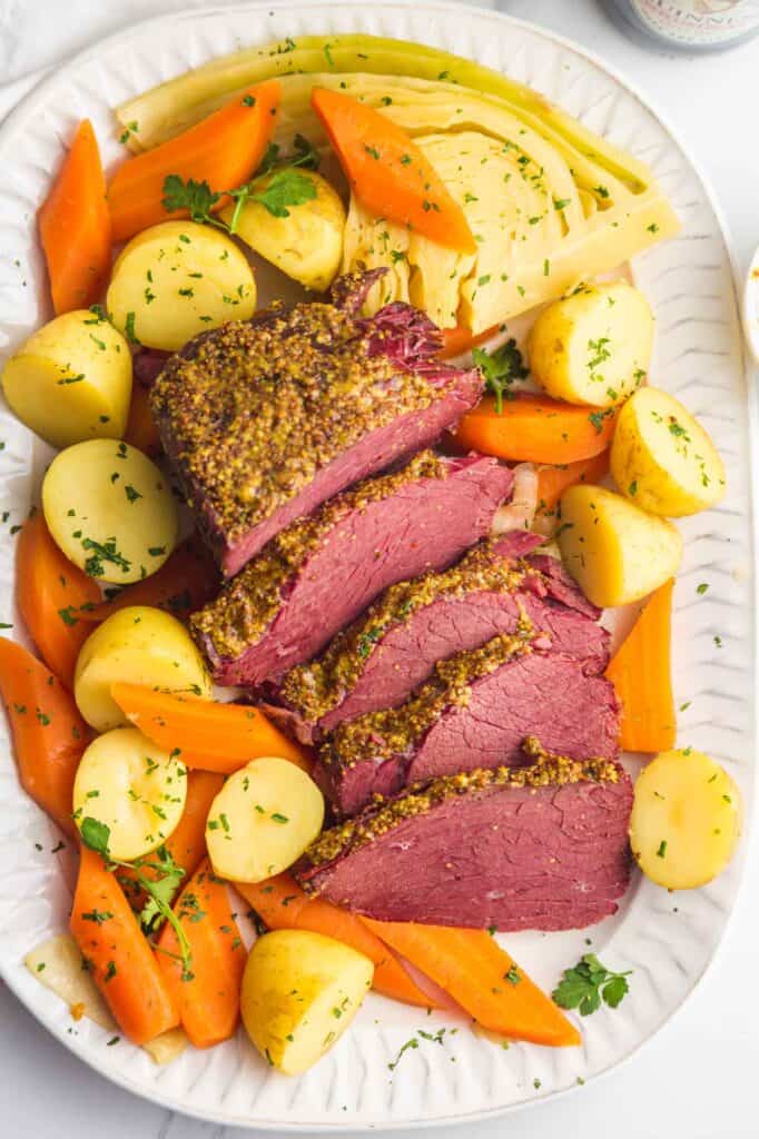 corned beef and cabbage cooked in an instant pot with carrots and potatoes on a serving plate
