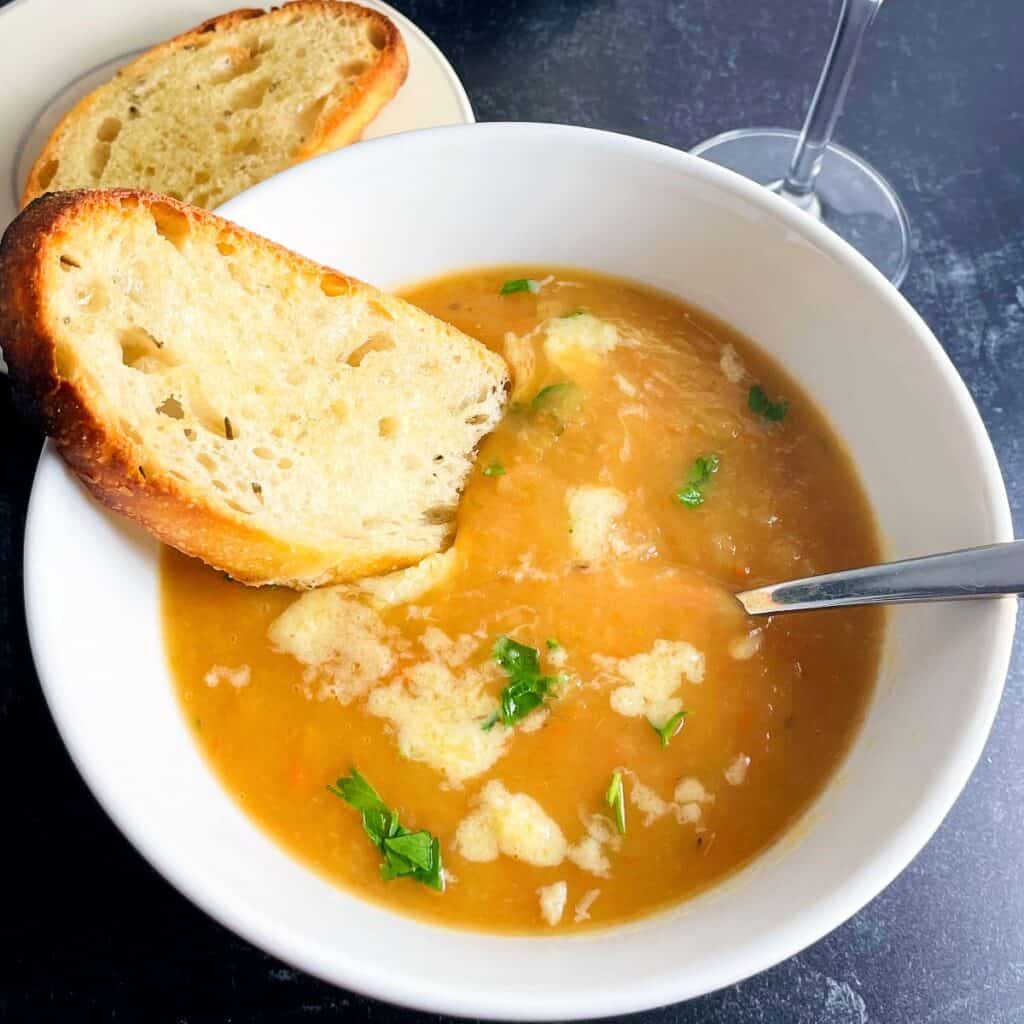irish vegetable soup in serving bowl with toasted bread and spoon