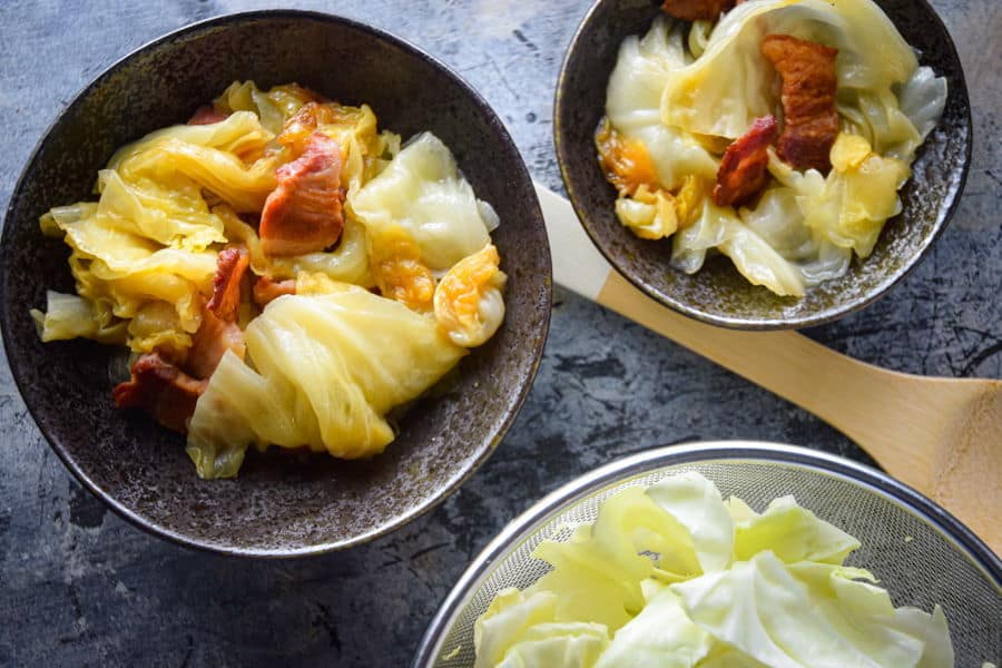 cabbage and bacon cooked in slow cooker in serving bowls 